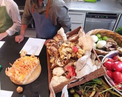 Canasta de hongos frescos y verduras en la cocina